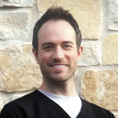 Jordan Harborth smiling in front of a stone wall.